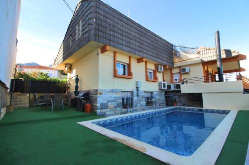 una casa con piscina frente a una casa en Chalet con piscina y barbacoa, en Polop