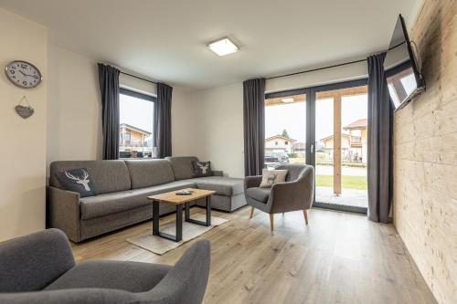 ein Wohnzimmer mit 2 Sofas und einem Tisch in der Unterkunft Inzell Chalets by ALPS RESORTS in Inzell