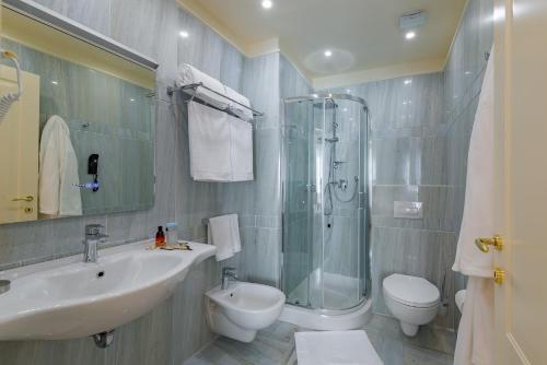 a bathroom with a sink and a shower and a toilet at La Paloma Blanca Hotel in Sciacca