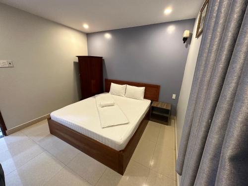 a small bedroom with a bed and a curtain at Bao Chieu Inn in Ha Tien