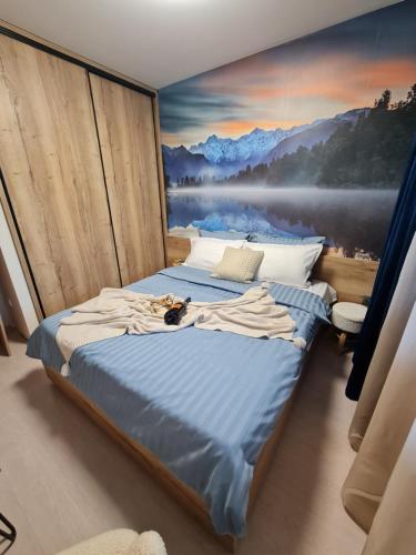 uma cama num quarto com uma pintura na parede em Mountain Paradise in Aparthotel Borovets Gardens em Borovets