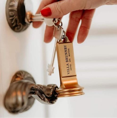 a person holding a key to a sink at Villa Brunnby in Mölle