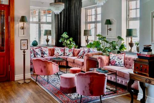 a living room with pink couches and chairs at Villa Brunnby in Mölle
