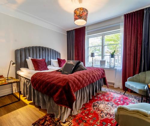 a bedroom with a bed with a red blanket at Villa Brunnby in Mölle