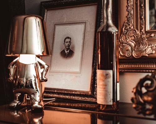 a lamp on a table with a picture of a man at Villa Brunnby in Mölle