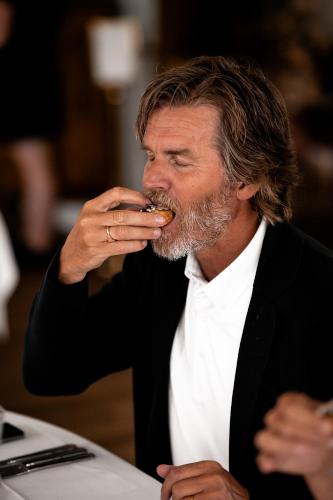 a man eating food while sitting at a table at Villa Brunnby in Mölle