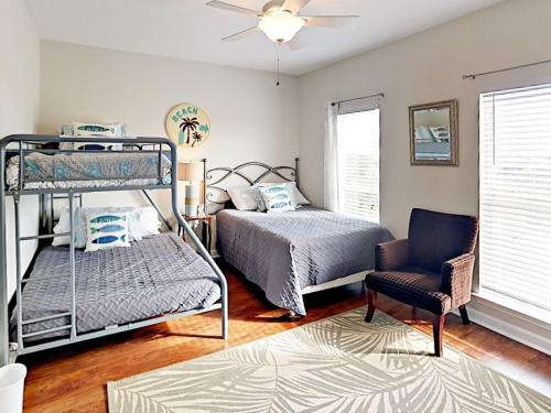 1 Schlafzimmer mit 2 Etagenbetten und einem Stuhl in der Unterkunft Bay Dreamin - Gulf Shores,Al in Gulf Shores