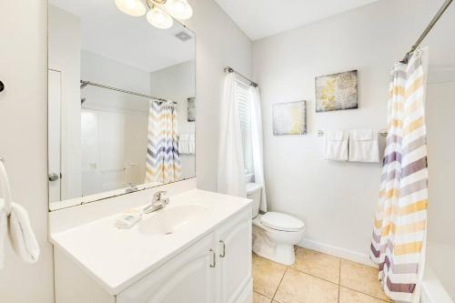 ein weißes Badezimmer mit Waschbecken und Toilette in der Unterkunft Bay Dreamin - Gulf Shores,Al in Gulf Shores