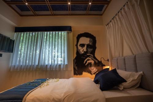 a bedroom with a picture of a man on the wall at Ra Residence - Agarwal Group of Hotels in Pune