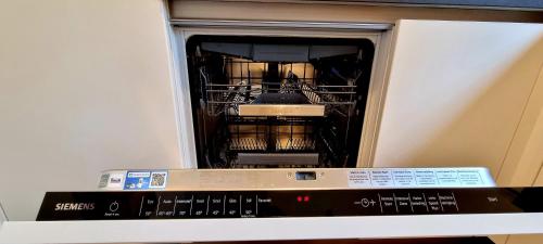 an open dishwasher with dishes inside of it at Bosfluiter in Halle