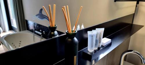 two black vases on a black shelf in a bathroom at Bosfluiter in Halle