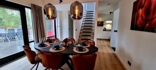 een eetkamer met een tafel en stoelen en een trap bij Bosfluiter in Halle