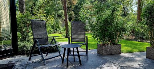 two chairs and a table on a patio at Bosfluiter in Halle