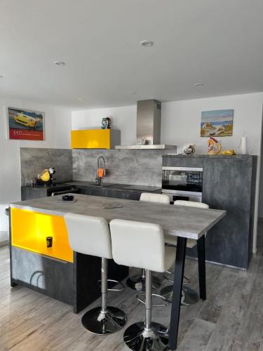 - une cuisine avec une table et des chaises blanches dans l'établissement La Marina de Lairan 2 chambres terrasse vue Port de Plaisance, au Grau-du-Roi