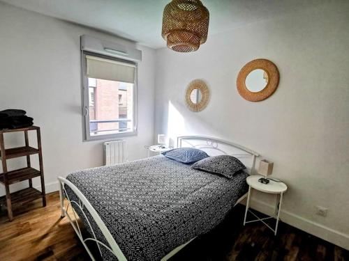 Un dormitorio con una cama y dos espejos en la pared. en Chez Serge - Petit Matabiau - 2/4 pers - Pkg/Centre, en Toulouse
