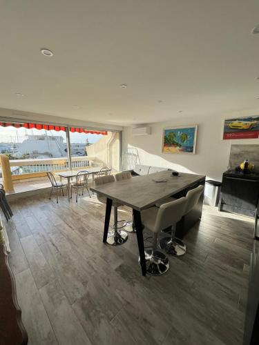 une salle à manger avec une table et des chaises dans l'établissement La Marina de Lairan 2 chambres terrasse vue Port de Plaisance, au Grau-du-Roi