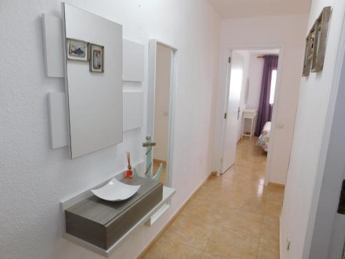 uma casa de banho com um lavatório e um espelho na parede em El Rincón de Maruca Primero C em Gran Tarajal