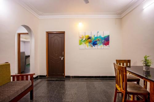 a dining room with a table and a door at Whiteboard Homes Siolim in Siolim
