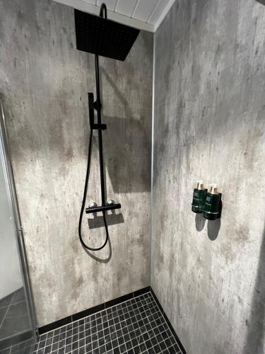 a shower in a bathroom with a shower head at Stryn House - Hotel & Apartments in Stryn