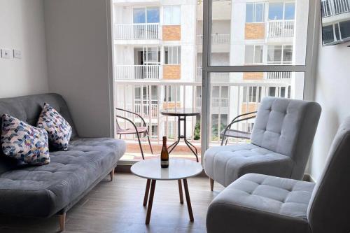 - un salon avec un canapé, deux chaises et une table dans l'établissement apartamento familiar villeta, à Villeta