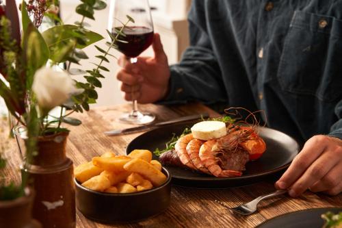 a table with a plate of food and a glass of wine at Pedn-Olva in St Ives