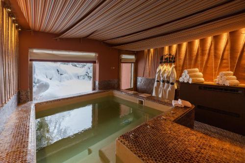 a swimming pool in the middle of a room with snow at Magic Megève Bois in Demi-Quartier