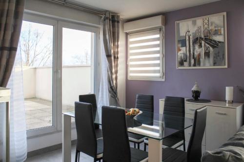 uma sala de jantar com uma mesa de vidro e cadeiras em Bright well-appointed nest near Stade de France em Saint-Denis