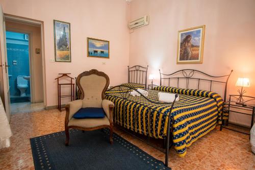 a bedroom with a bed and a chair in it at Aci B&B in Acireale
