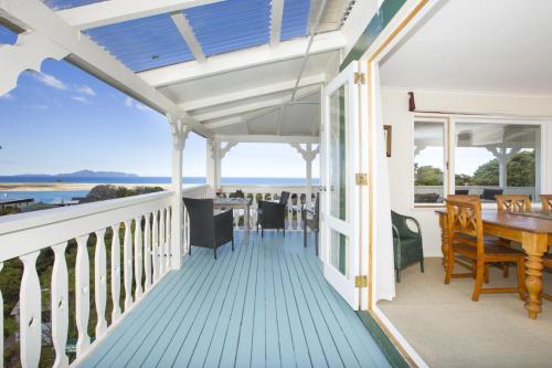 a porch with a blue deck with a table and chairs at Mangawhai Lodge in Mangawhai