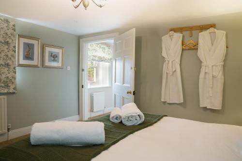 a bedroom with a bed with towels and a window at Gardeners Cottage, Wynyard Hall 