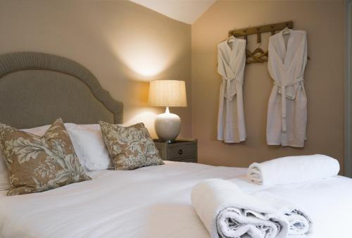 a bedroom with a white bed with towels on it at Gardeners Cottage, Wynyard Hall 