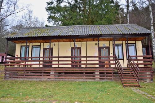 a small house with a wooden fence in a field at Areál Ontario Kyselka in Kysibl Kyselka