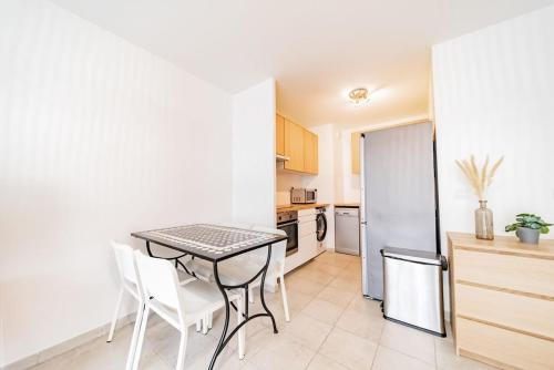 a kitchen with a table and chairs and a refrigerator at Charming T2 (44M2) bright with Terrace in Villeurbanne
