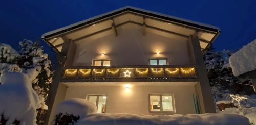a house with christmas lights on the balcony at night at Residence Alba Montis in Bad Kleinkirchheim