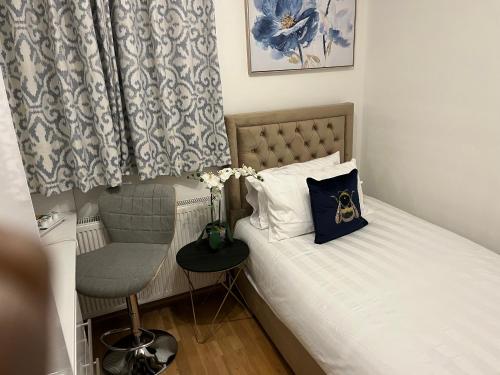 a small bedroom with a bed and a chair at TJ Homes - Luxury Studio Suite with Garden View - Next to tube station London in Ruislip