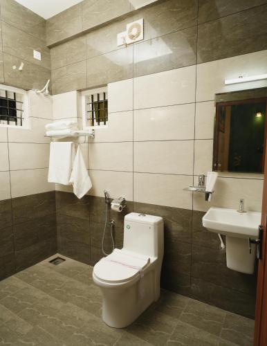 a bathroom with a toilet and a sink at AVANTI CASTELLO in Guruvāyūr