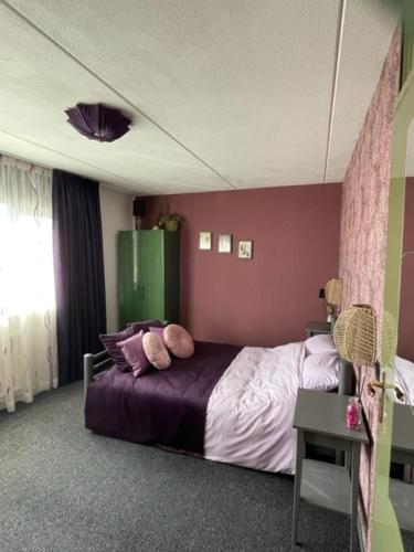 een slaapkamer met een bed met paarse muren bij Bed and breakfast devijfbees in Barendrecht