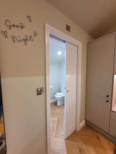 a room with a bathroom with a toilet and a door at Wheelwright's Rest, Legbourne, Louth in Louth
