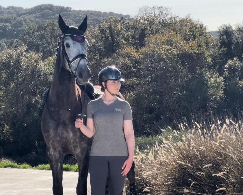 Uma mulher está ao lado de um cavalo. em Les Chevaux de Coeur em Estepona