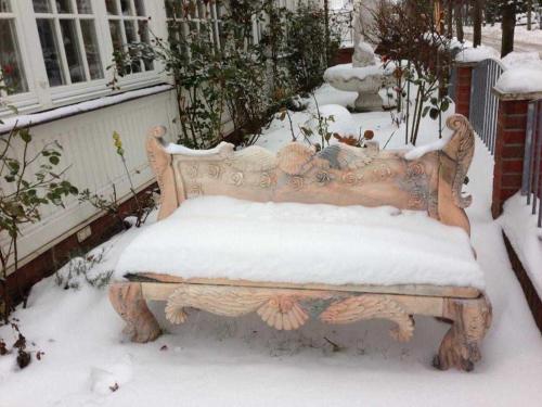 a bench covered in snow in front of a house at Villa Waldrose in Binz