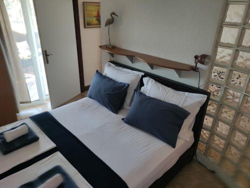 um quarto com uma cama com almofadas azuis e brancas em Apartments Blanca em Vodice