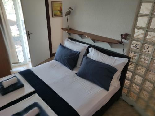 a bedroom with a bed with blue and white pillows at Apartments Blanca in Vodice