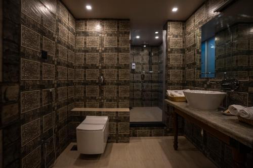a bathroom with two sinks and a toilet and a tub at Ra Residence - Agarwal Group of Hotels in Pune
