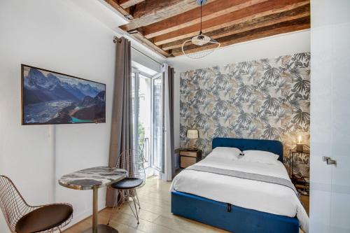 1 dormitorio con 1 cama azul, mesa y sillas en Apartments for Work in City Center, en París