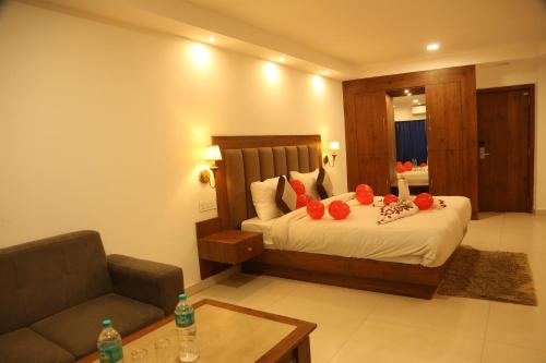 a bedroom with a bed and a couch and a table at Sambodhi Retreat in Dhanbād