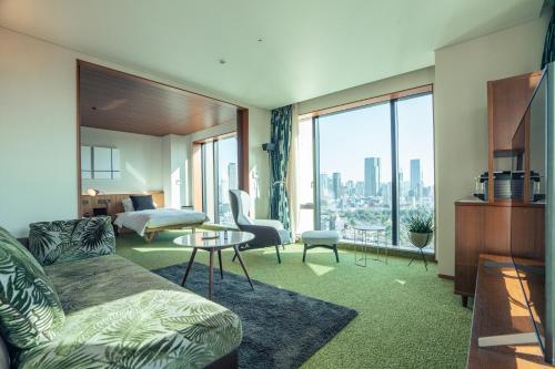 sala de estar con sofá y vistas a la ciudad en THE AOYAMA GRAND HOTEL en Tokio