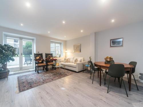 een woonkamer met een tafel en een bank bij Pass the Keys Modern Apartment 2 Minute Walk From Station in Surbiton