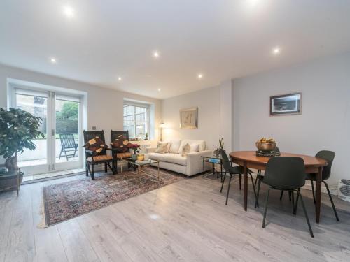 a living room with a table and a couch at Pass the Keys Modern Apartment 2 Minute Walk From Station in Surbiton