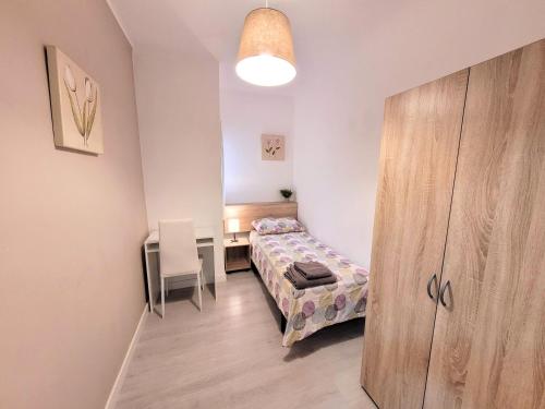 niewielka sypialnia z łóżkiem i biurkiem w obiekcie Bed&BCN Forum w mieście Sant Adria de Besos