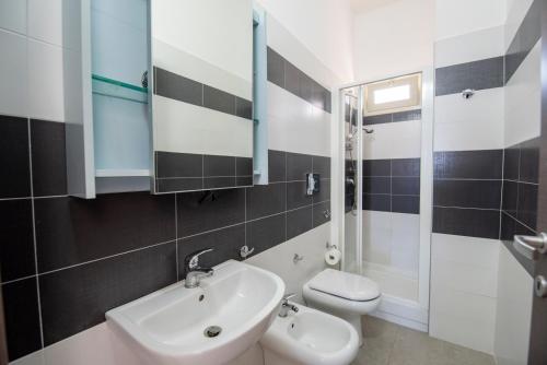 uma casa de banho com um lavatório, um WC e um espelho. em House Calabernardo Sea Beach - Sicilia Vacanza em Calabernardo